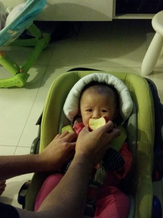 Daddy's idea of a celebration - letting Emma try his apple. Her first contact with real food. 